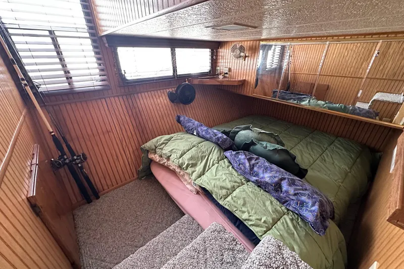 Slide: The Image of Cozy bedroom in 1993 Sumerset 14x65 houseboat with wood paneling and fishing rods. - 8