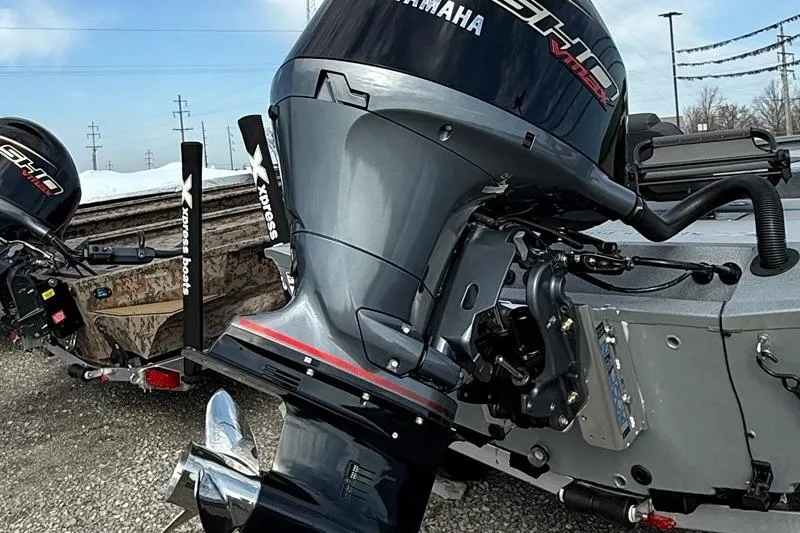 Slide: The Image of 2026 Express H20C boat with Yamaha outboard motor, parked on gravel. - 2