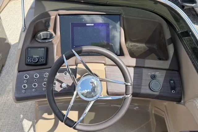 Slide: The Image of 2021 Bennington QX 25 QXSBWA boat dashboard with steering wheel and control panel. - 14
