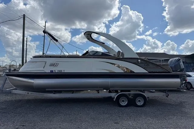 Slide: The Image of 2021 Bennington QX 25 QXSBWA pontoon boat on trailer under cloudy sky. - 3