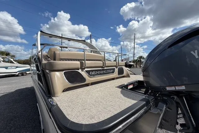 Slide: The Image of 2021 Bennington QX 25 QXSBWA pontoon boat with Yamaha engine, under a partly cloudy sky. - 7