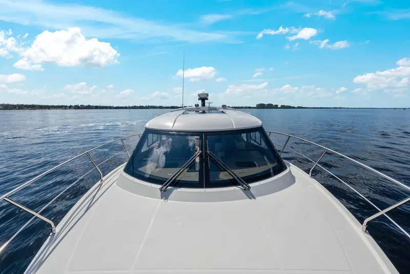 Slide: The Image of 2016 Carver C37 Coupe yacht cruising on open water under a clear blue sky. - 11