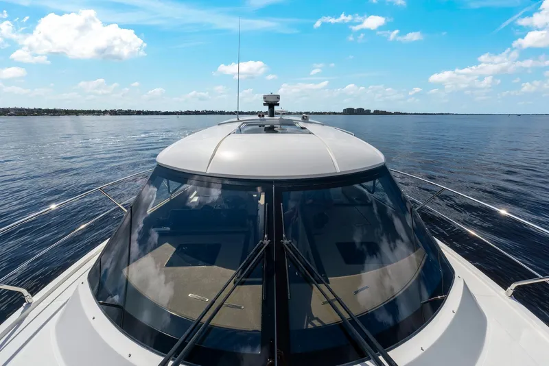 Slide: The Image of 2016 Carver C37 Coupe yacht cruising on open water under a clear blue sky. - 12