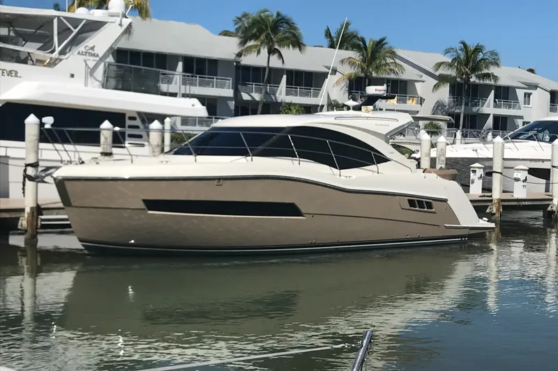 Slide: The Image of 2016 Carver C37 Coupe yacht docked at marina with palm trees and buildings. - 13