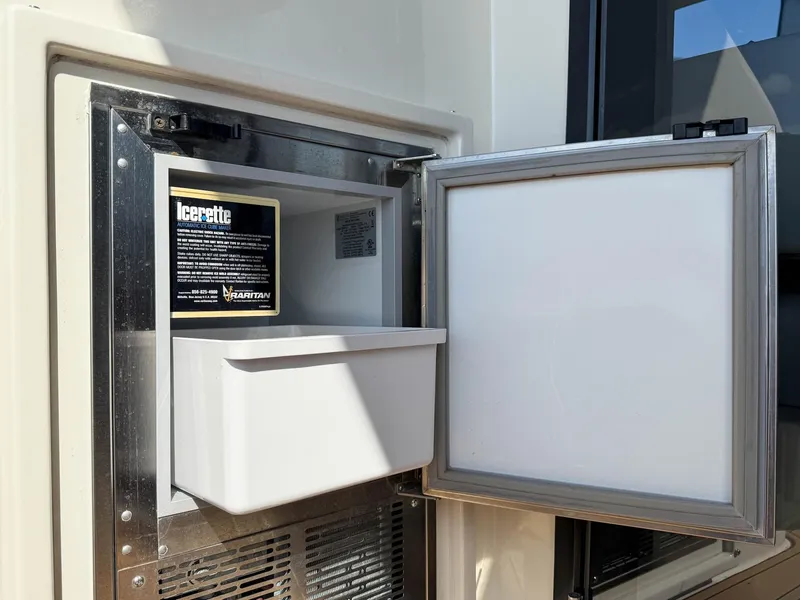 Slide: The Image of Ice maker in 2016 Carver C37 Coupe yacht, open with visible ice tray. - 28