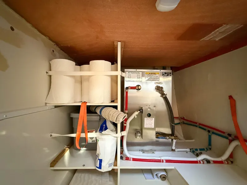 Slide: The Image of Storage compartment in a 2016 Carver C37 Coupe with plumbing and supplies. - 42