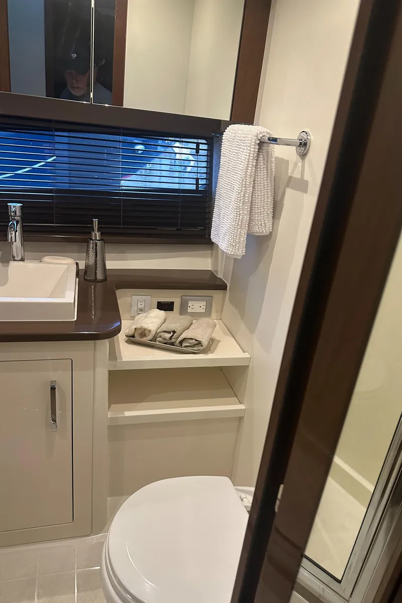 Slide: The Image of 2016 Carver C37 Coupe bathroom with sink, toilet, and shower. - 54