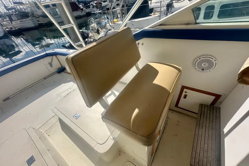 Slide: The Image of 1985 Bertram 28 Bahia Mar boat interior with tan seating and marina view. - 2