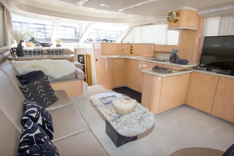 Slide: The Image of Luxurious interior of 1998 Sea Ray 480 Sedan Bridge yacht with modern kitchen and seating area. - 11