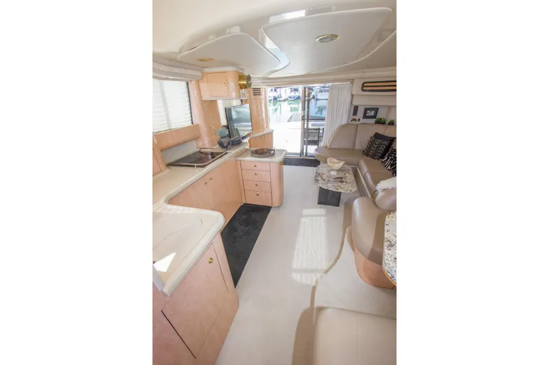 Slide: The Image of Interior of 1998 Sea Ray 480 Sedan Bridge yacht, featuring modern kitchen and seating area. - 12