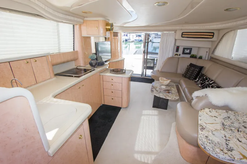 Slide: The Image of Luxurious interior of 1998 Sea Ray 480 Sedan Bridge yacht with modern kitchen and seating area. - 13