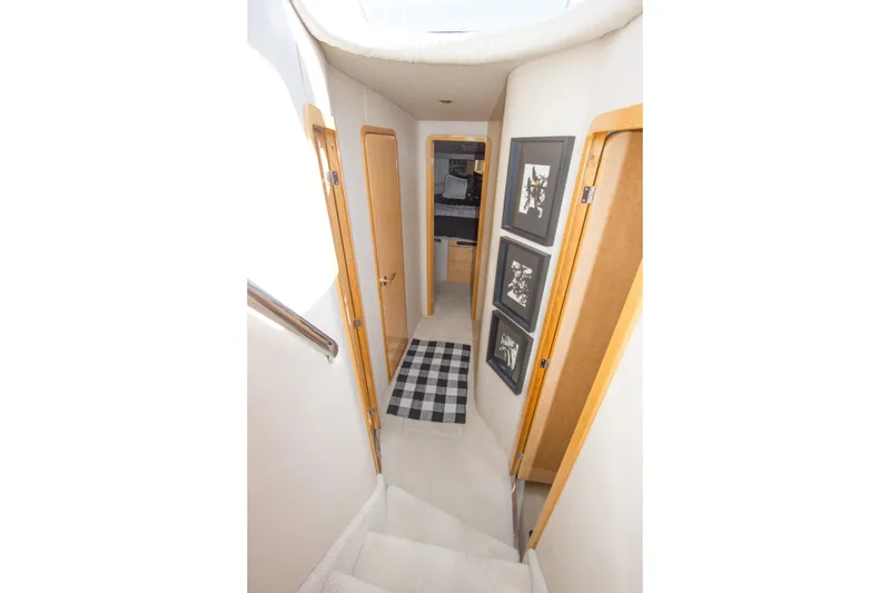 Slide: The Image of Interior hallway of 1998 Sea Ray 480 Sedan Bridge yacht, featuring wooden doors and framed artwork. - 22