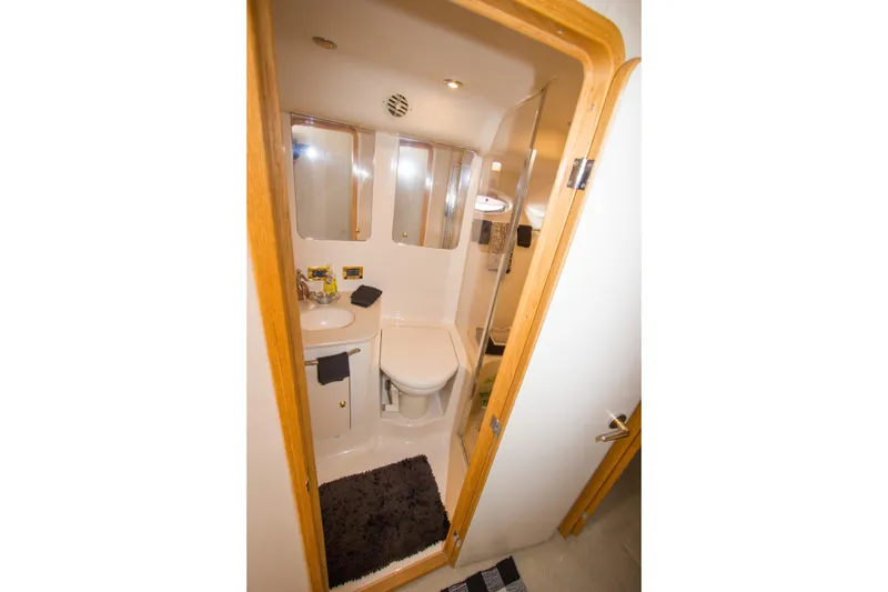 Slide: The Image of Bathroom interior of 1998 Sea Ray 480 Sedan Bridge yacht, featuring sink and toilet. - 25