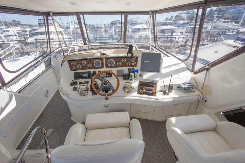 Slide: The Image of 1998 Sea Ray 480 Sedan Bridge helm with leather seats and panoramic marina view. - 30