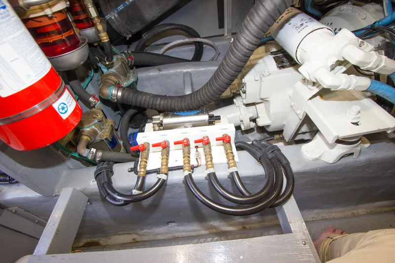 Slide: The Image of Engine compartment of 1998 Sea Ray 480 Sedan Bridge with hoses and valves visible. - 43