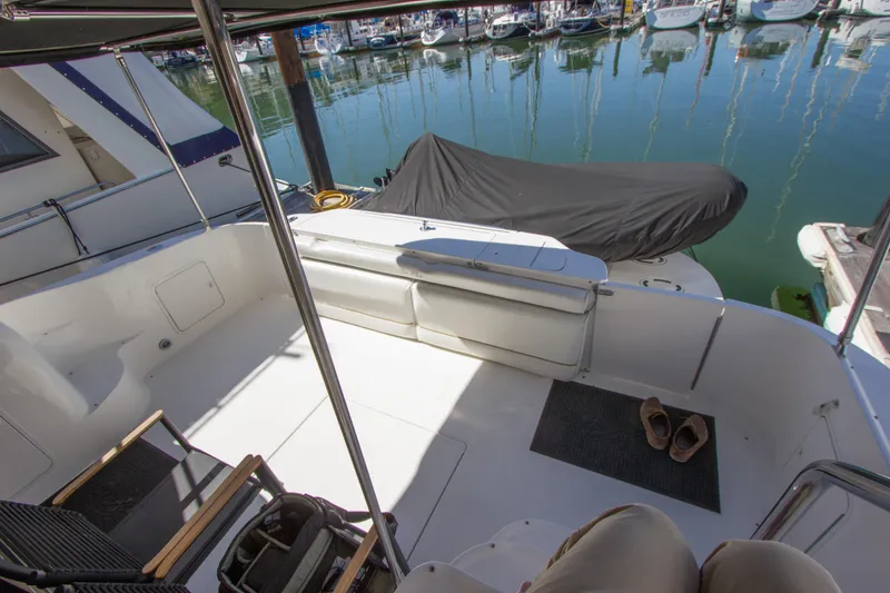 Slide: The Image of 1998 Sea Ray 480 Sedan Bridge yacht deck with seating, docked at marina. - 8