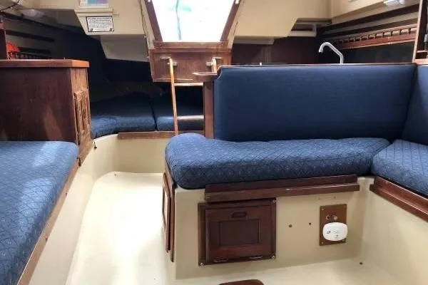 Slide: The Image of Interior of a 1981 Catalina 30 sailboat with blue cushioned seating. - 10