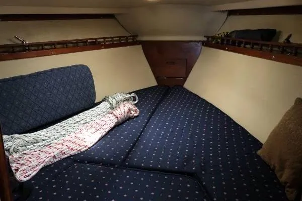 Slide: The Image of Interior cabin of 1981 Catalina 30 sailboat with blue patterned cushions and coiled rope. - 12