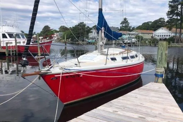 Slide: The Image of 1981 Catalina 30 sailboat cockpit with weathered wood hatch and marina background. - 22