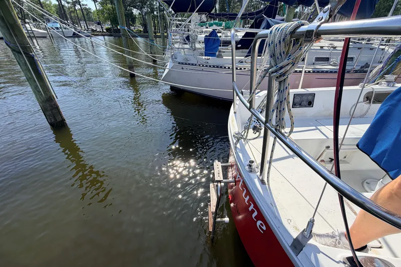 Slide: The Image of Interior of a 1981 Catalina 30 sailboat with blue seating and wooden cabinetry. - 28