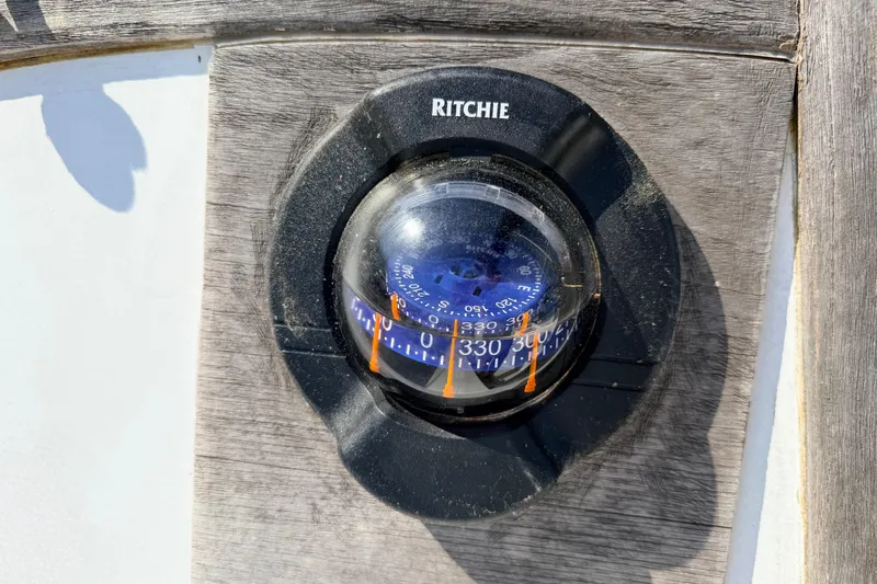 Slide: The Image of Interior of a 1981 Catalina 30 sailboat with wooden furnishings and blue seating. - 30