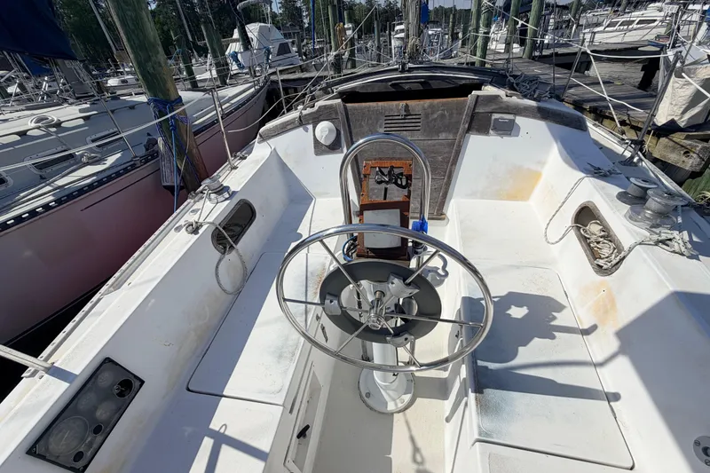 Slide: The Image of Interior of a 1981 Catalina 30 sailboat with blue cushioned seating. - 32