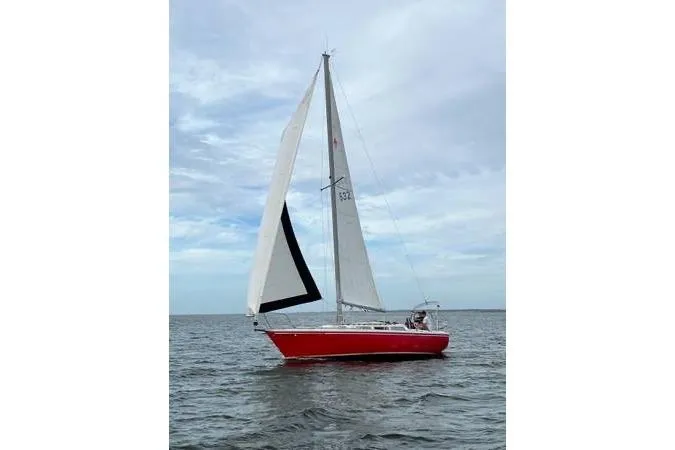 Slide: The Image of 1981 Catalina 30 sailboat with red hull sailing on open water. - 4