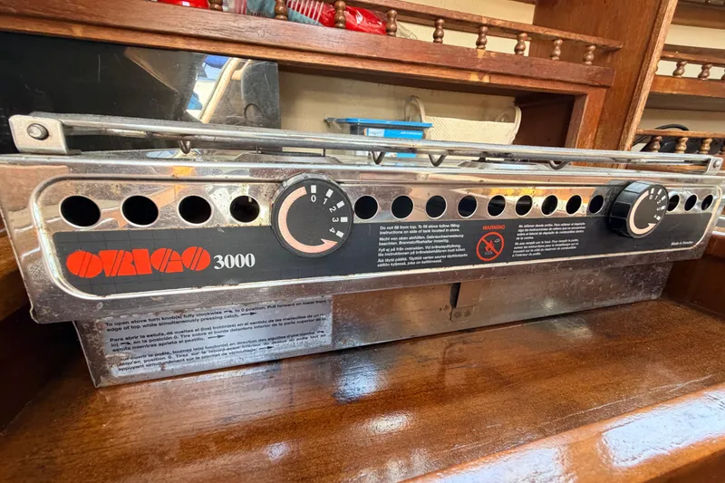 Slide: The Image of Interior of a 1981 Catalina 30 sailboat with blue seating and wooden cabinetry. - 47