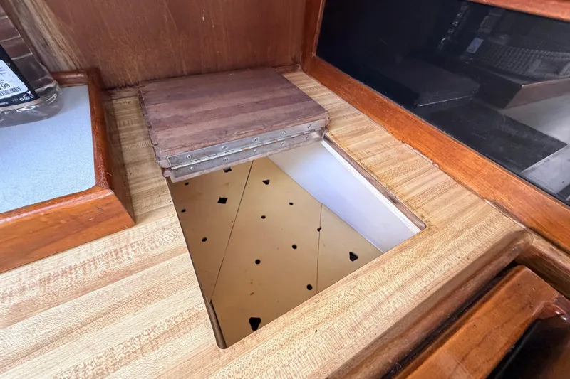 Slide: The Image of Interior of a 1981 Catalina 30 sailboat with wooden cabinetry and nautical decor. - 48