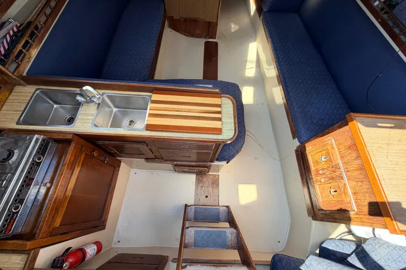 Slide: The Image of Boat bathroom with white toilet, wooden paneling, and cleaning brush on a 1981 Catalina 30. - 52
