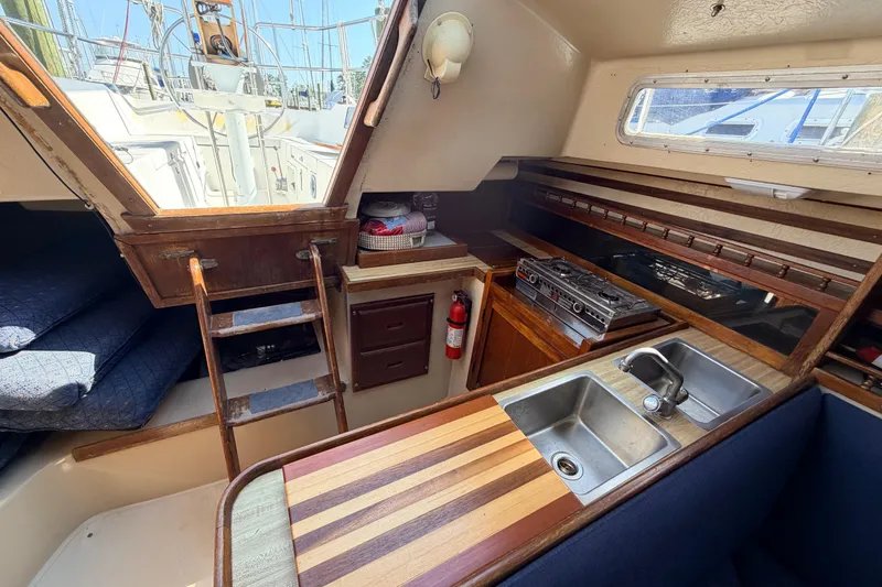 Slide: The Image of Interior of 1981 Catalina 30 sailboat with wooden cabinetry and blue seating. - 55