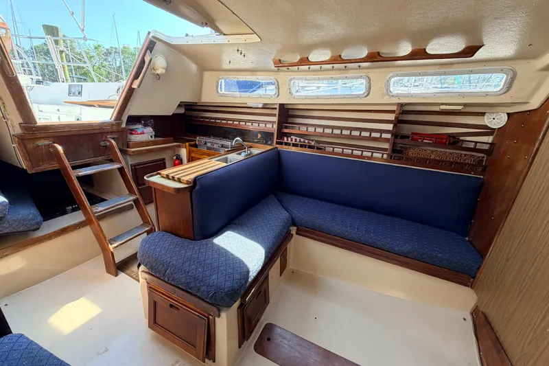 Slide: The Image of Interior cabin of 1981 Catalina 30 sailboat with blue patterned cushions and coiled rope. - 56