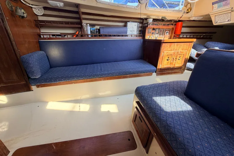 Slide: The Image of Engine compartment of a 1981 Catalina 30 sailboat, showcasing mechanical components and wooden paneling. - 57
