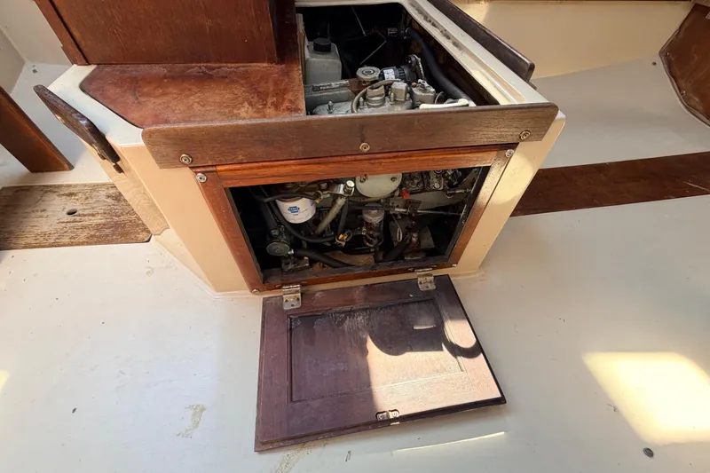 Slide: The Image of 1981 Catalina 30 sailboat with red hull sailing on open water under blue sky. - 63