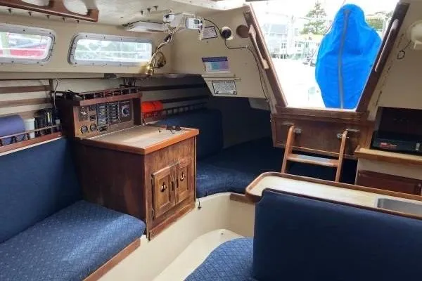 Slide: The Image of Interior of a 1981 Catalina 30 sailboat with blue seating and wooden cabinetry. - 7