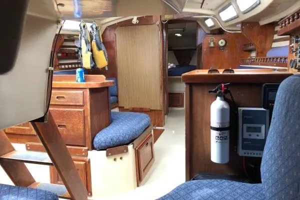 Slide: The Image of Interior of 1981 Catalina 30 sailboat with wooden furnishings and blue upholstery. - 9