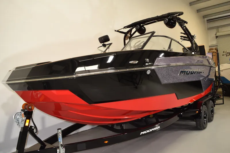 Slide: The Image of 2026 Moomba Max boat in showroom, featuring sleek black and red design. - 4