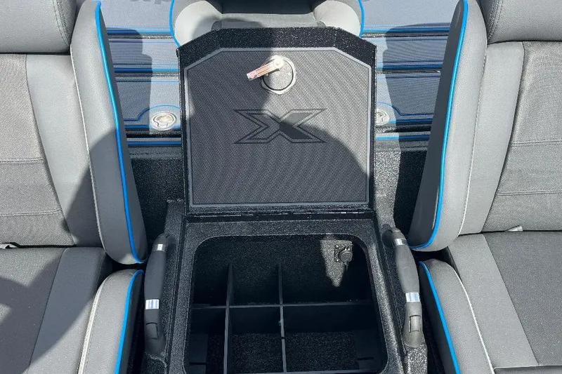 Slide: The Image of 2026 Xpress XR21 Bass boat interior with open storage compartment and blue-accented seats. - 10