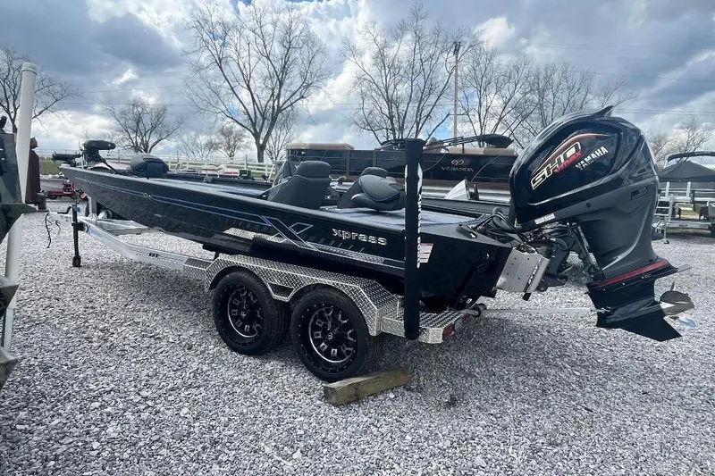 Slide: The Image of 2026 Xpress XR21 Bass boat with Yamaha engine on a trailer, parked on gravel. - 3