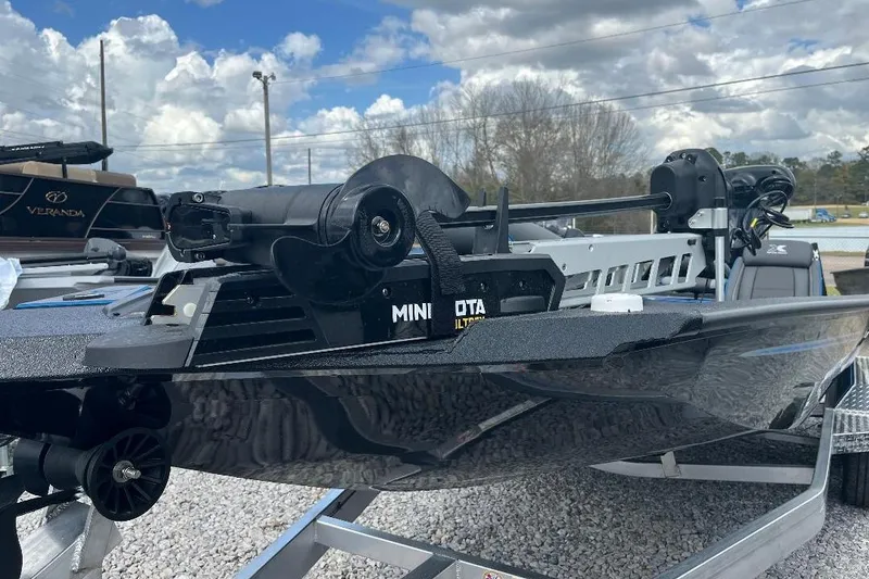 Slide: The Image of 2026 Xpress XR21 Bass boat with Minn Kota motor on a trailer, under cloudy sky. - 4