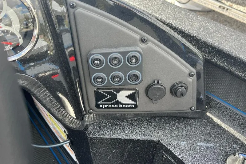Slide: The Image of Control panel of 2026 Xpress XR21 Bass boat with switches and logo. - 7
