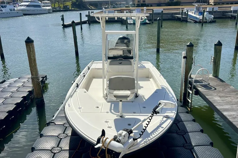 Slide: The Image of 2021 Mako 21 LTS boat docked at marina with clear water view. - 18