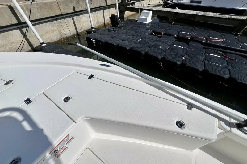 Slide: The Image of 2021 Mako 21 LTS boat docked, featuring a clean white deck and floating dock. - 22