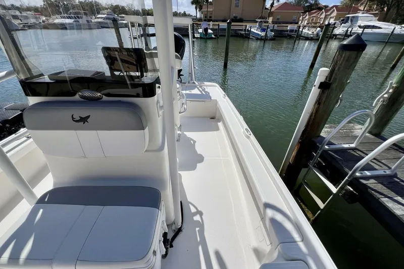 Slide: The Image of 2021 Mako 21 LTS boat docked at marina, featuring spacious deck and seating. - 27