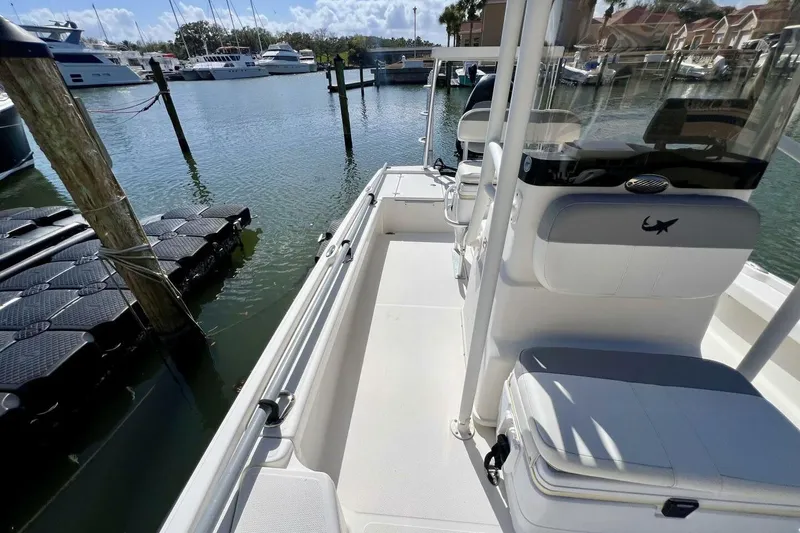Slide: The Image of 2021 Mako 21 LTS boat docked at marina with clear skies and calm waters. - 28