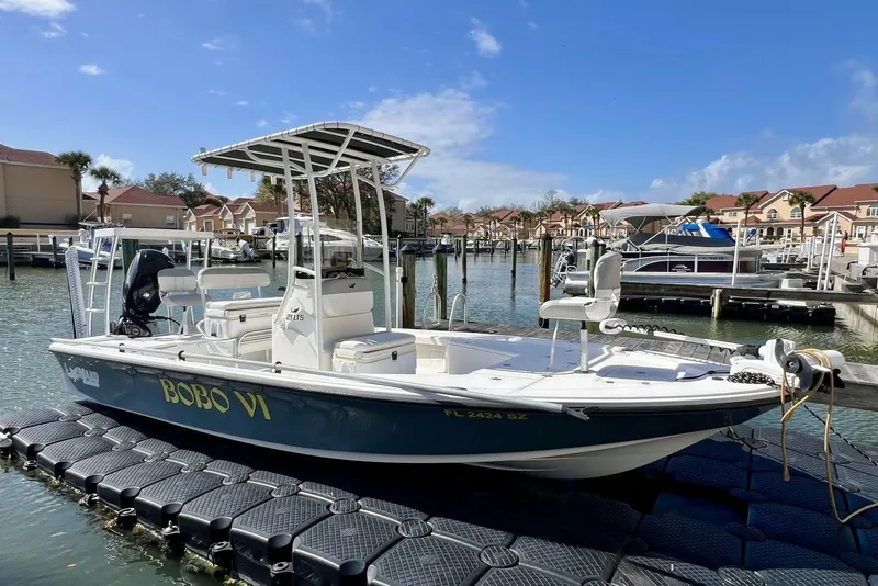 Slide: The Image of 2021 Mako 21 LTS boat docked in a marina under a clear blue sky. - 3