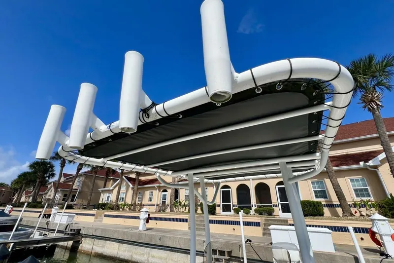 Slide: The Image of 2021 Mako 21 LTS boat with rod holders, docked under clear blue sky. - 32