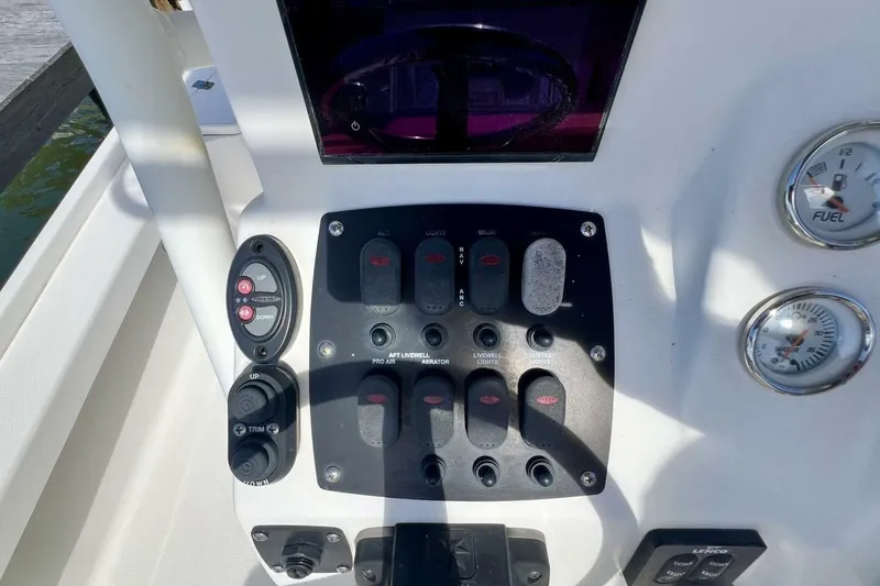 Slide: The Image of Control panel of a 2021 Mako 21 LTS boat with switches and gauges. - 35