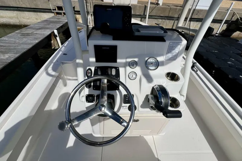 Slide: The Image of 2021 Mako 21 LTS boat console with steering wheel and navigation instruments. - 36