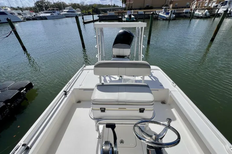 Slide: The Image of 2021 Mako 21 LTS boat docked in marina, featuring steering console and seating. - 43